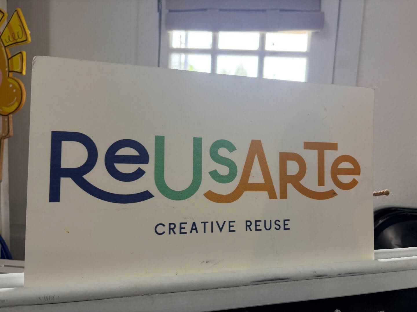 The ReUsArte creative-reuse sign set up at Twists & Tales for a hand-stitching workshop.