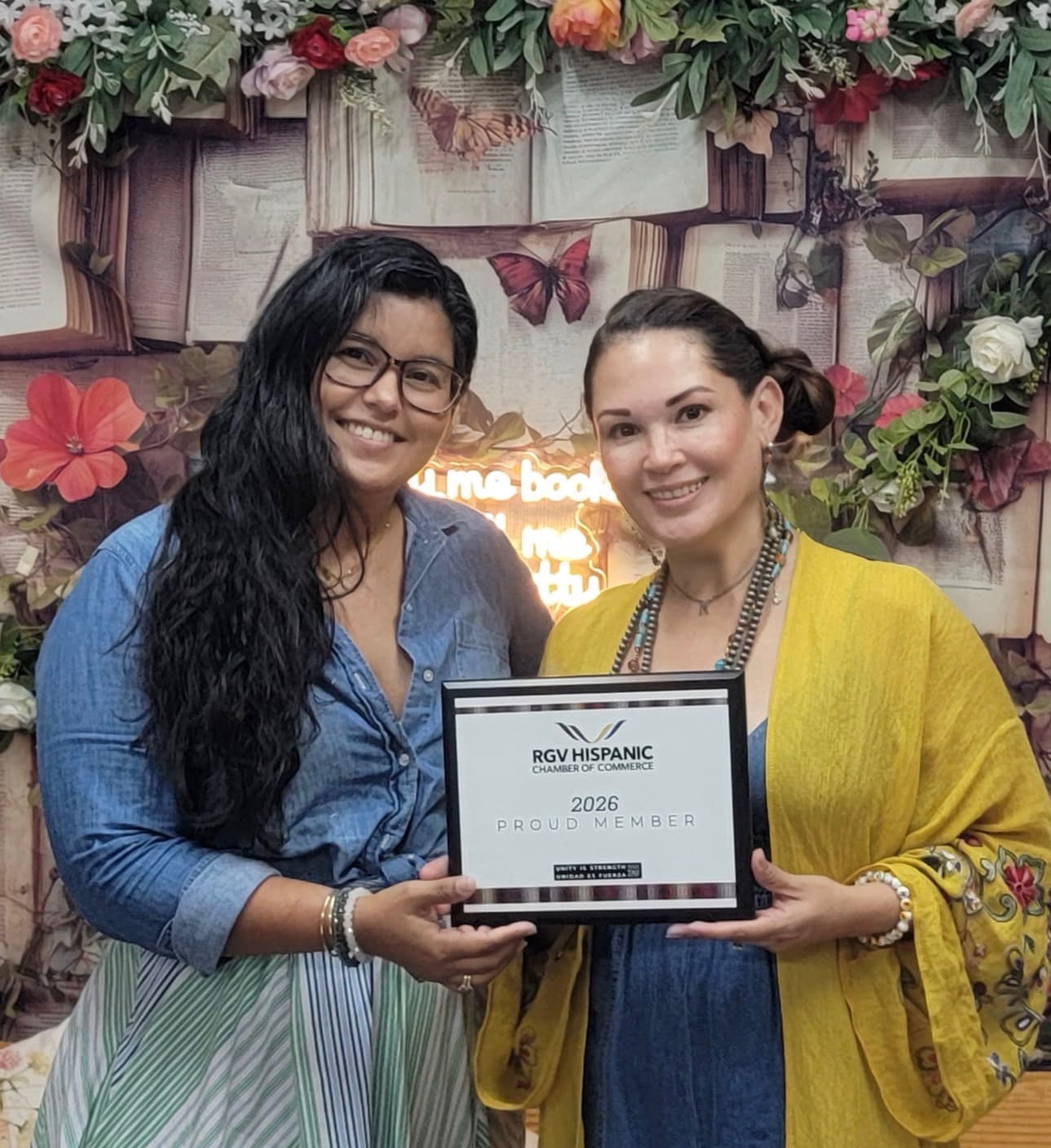 The Twists & Tales owners smiling together while holding their 2026 RGV Hispanic Chamber of Commerce Proud Member certificate.